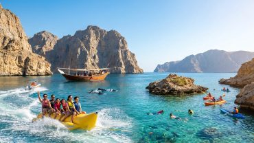 Families and groups enjoying water sports in Musandam near Khasab's scenic fjords